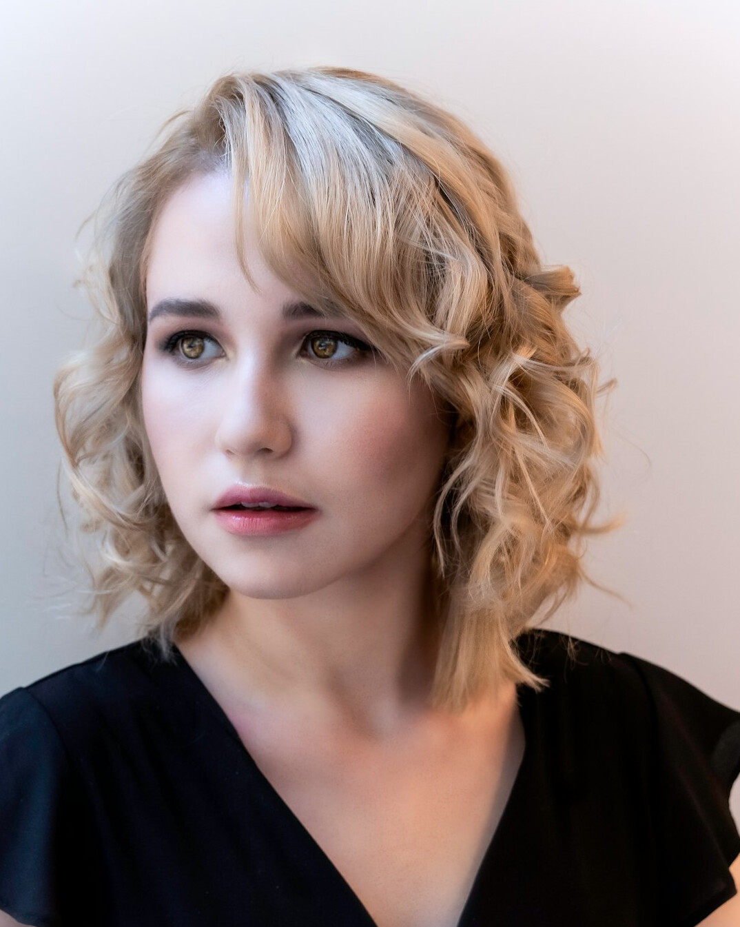 Studio portrait of a young woman with wavy blonde hair